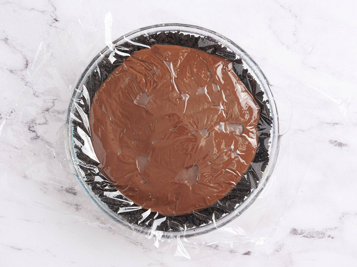 A Mississippi Mud Pie covered in plastic wrap.