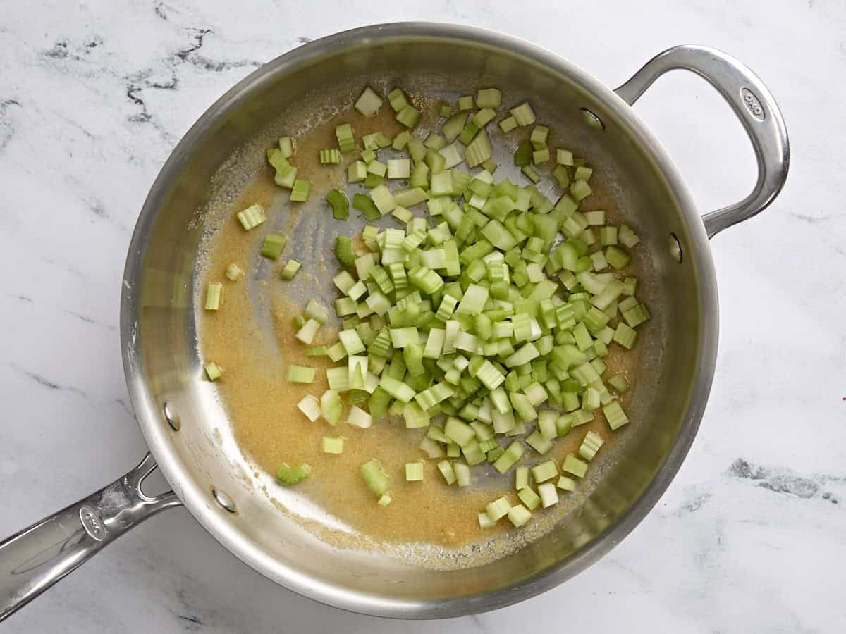 Diced celery added to a saucepan.