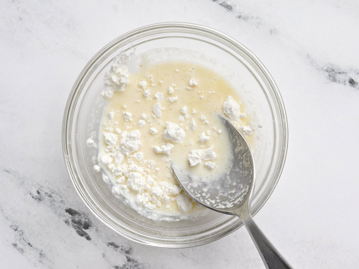 Milk and cornstarch being combined in a small bowl.