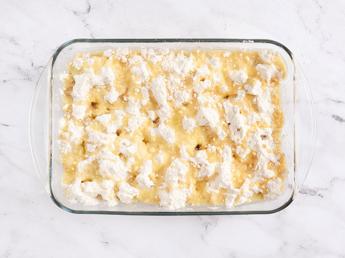 An apple dump cake in a baking dish before baking.