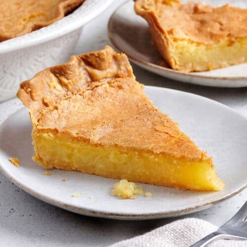 Side view of a slice of homemade chess pie on a plate.