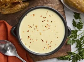Overhead view of a bowl of cream of chicken soup.