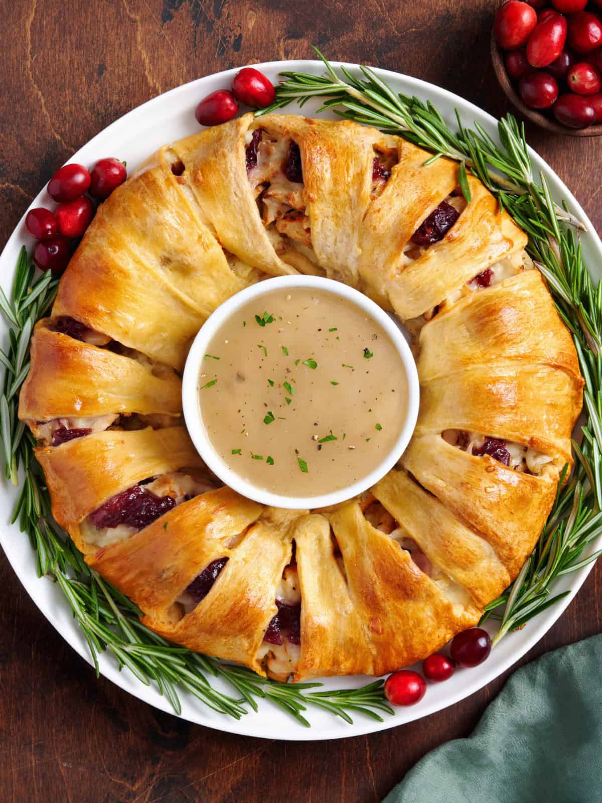 Overhead view of a holiday wreath with a bowl of gravy in the middle.
