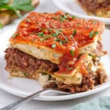 Side view of a slice of vegan lasagna with a fork.