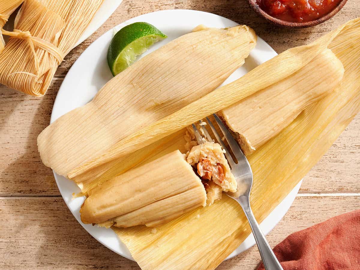 Overhead view of tamales on a plate with a fork.