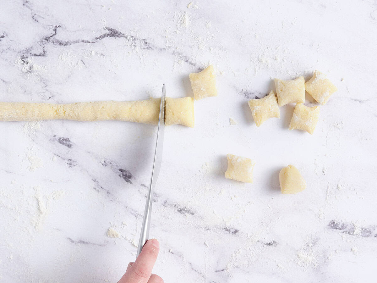 Cutting the gnocchi dough into pieces.