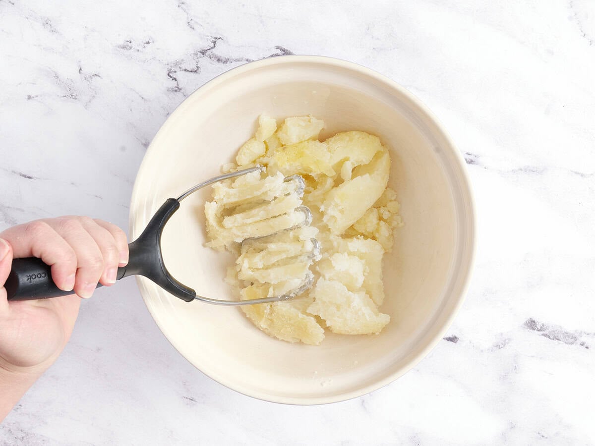 Mashing the potatoes.