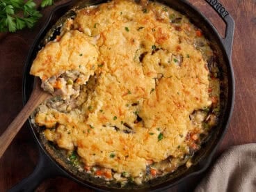 Overhead view of a homemade chicken cobbler with a spoon taking some.