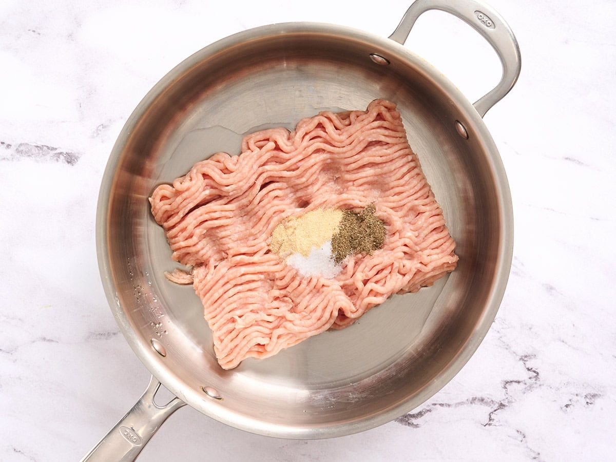 Ground chicken and seasonings in a skillet.