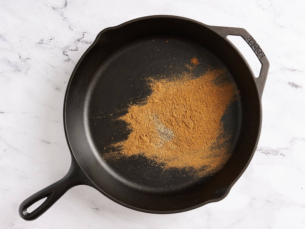 Spices toasting in a skillet.