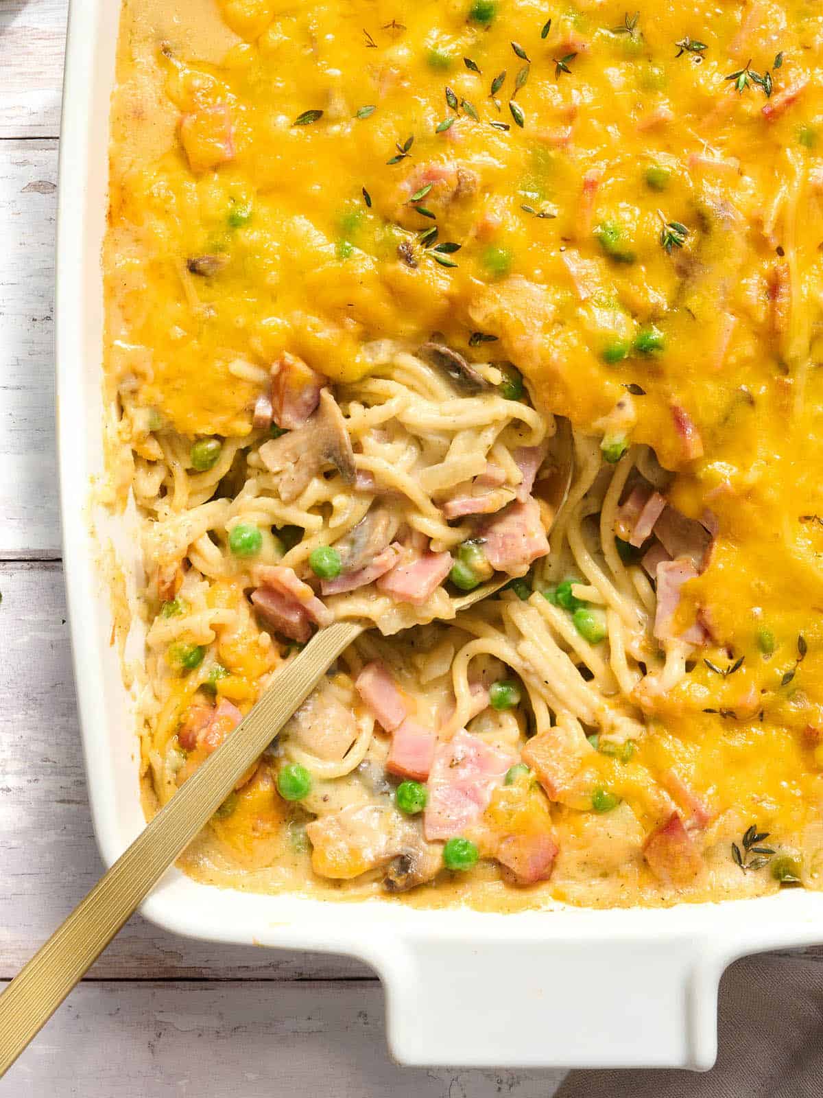 Overhead view of ham tetrazzini in a casserole dish with a spoon.