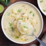 Overhead view of potato leek soup in a bowl with a spoon.