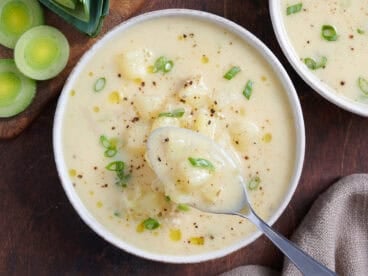 Overhead view of potato leek soup in a bowl with a spoon.
