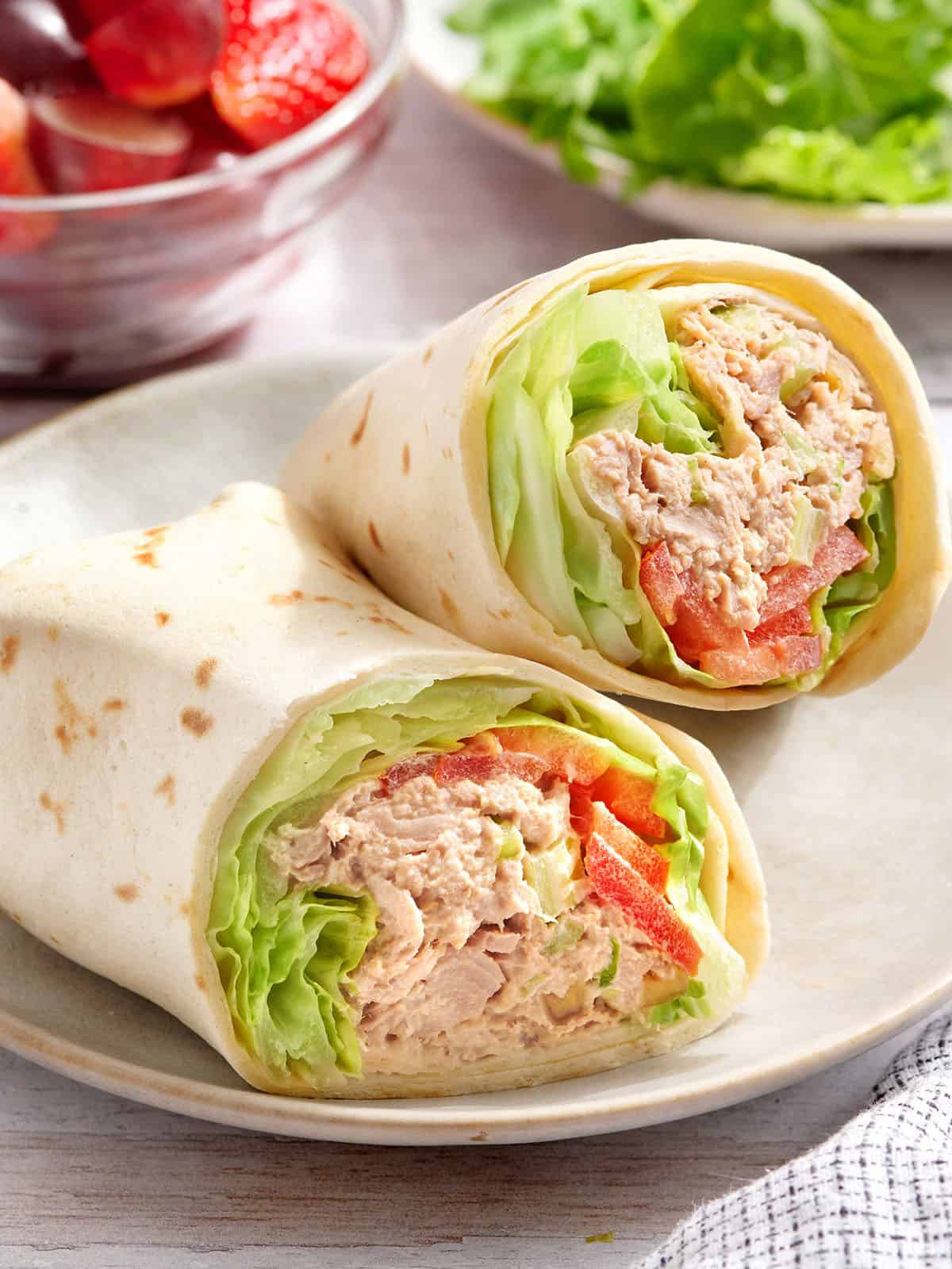 A tuna wrap sliced in half on a plate.