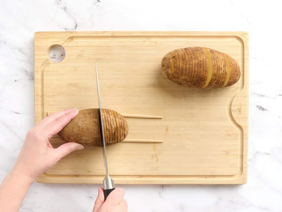 Potatoes being sliced with chopsticks being used as a guide.