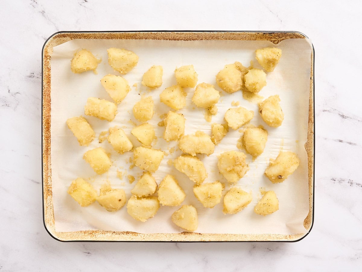Potatoes on a parchment lined baking sheet.