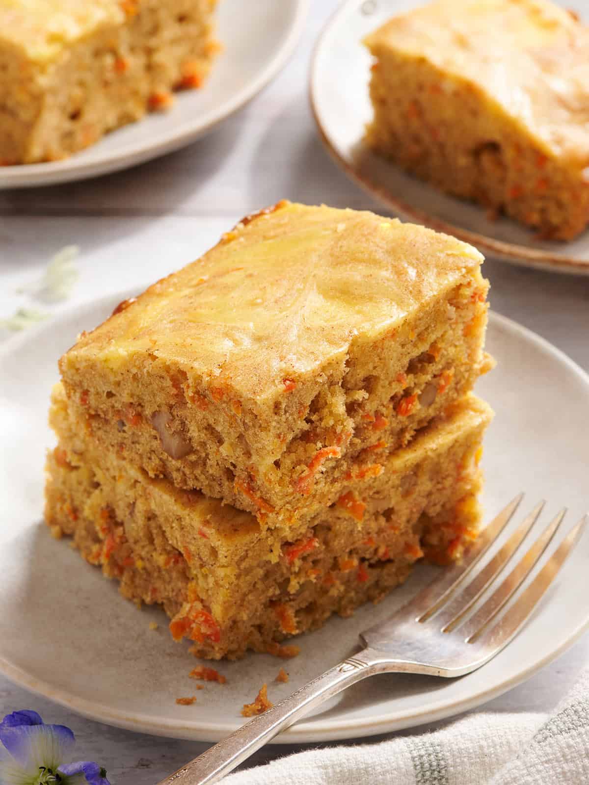 Side view of carrot cake bars on a plate.