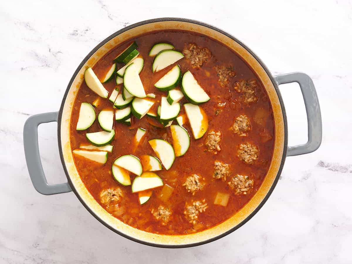 Zucchini added to a pot of Mexican meatball soup (Albóndigas).