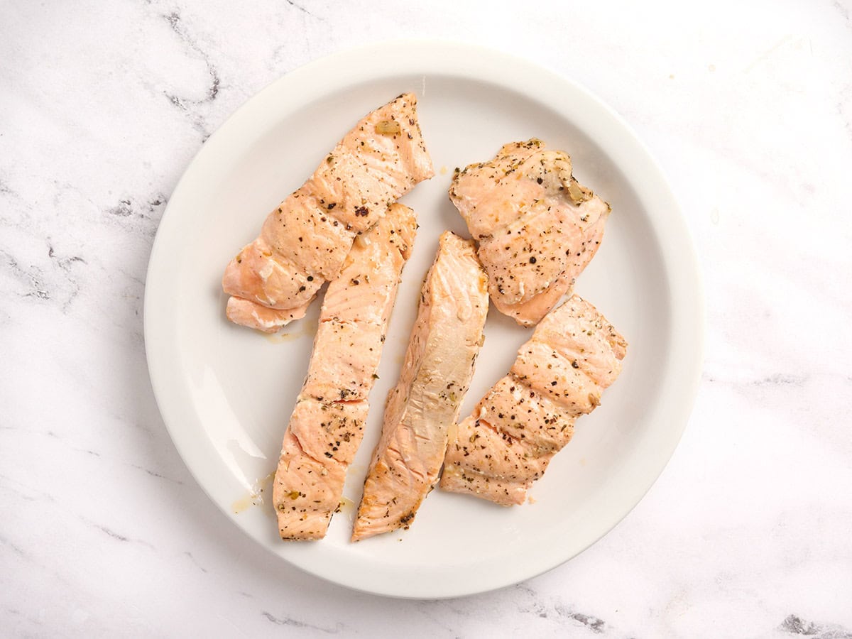 Cooked salmon fillets on a plate.