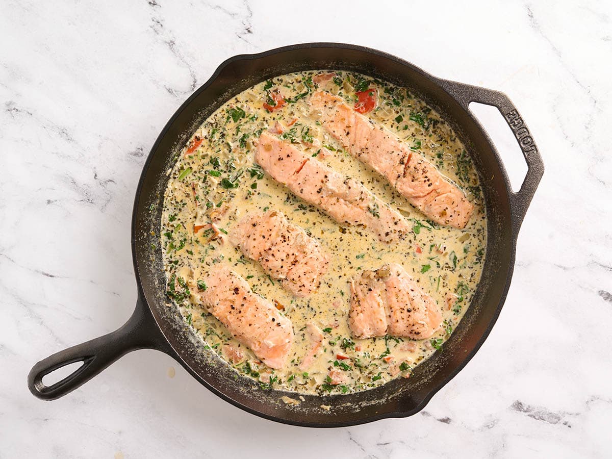 Tuscan salmon and a creamy sauce in a skillet.