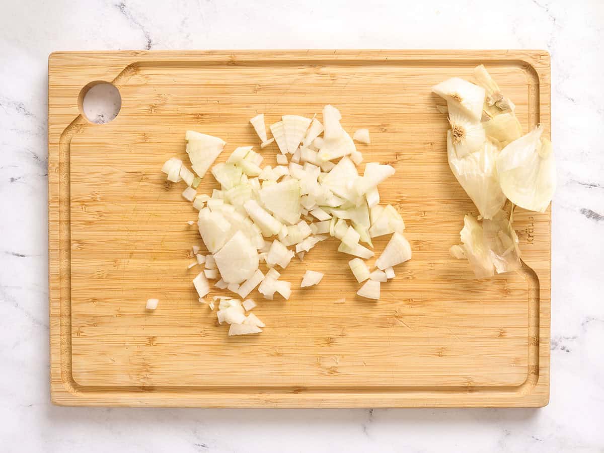 Diced onion on a wooden cutting board.