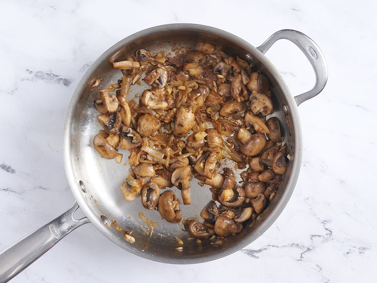 Onions, garlic and mushrooms in a skillet.