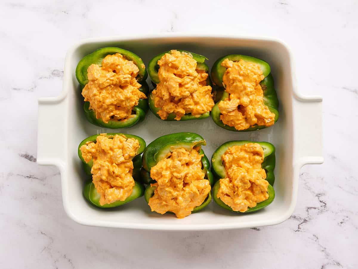 Green bell pepper halves stuffed with buffalo chicken filling.