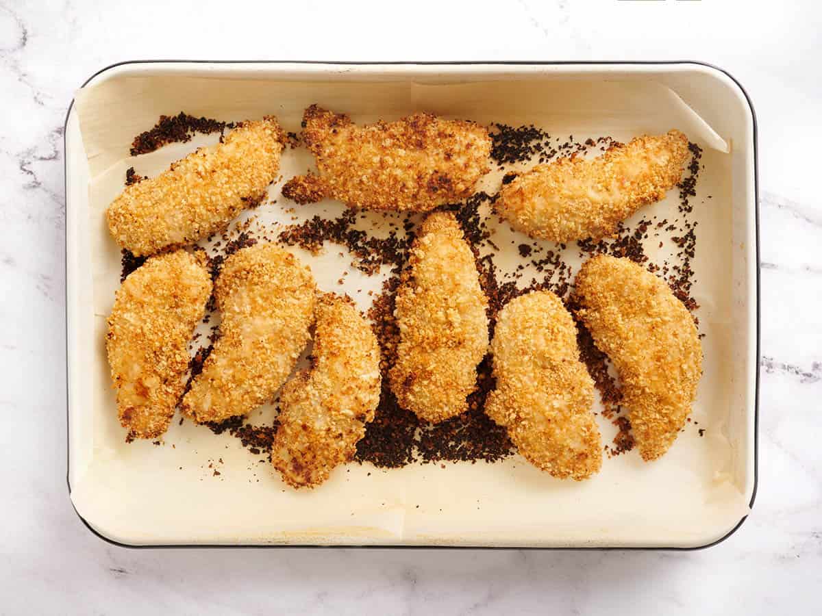 Chicken tenders after cooking on a baking sheet.