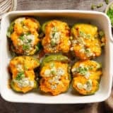 Overhead view of creamy buffalo chicken stuffed peppers in a baking dish.