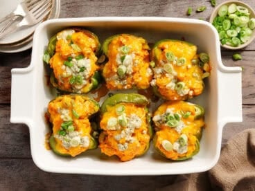 Overhead view of creamy buffalo chicken stuffed peppers in a baking dish.