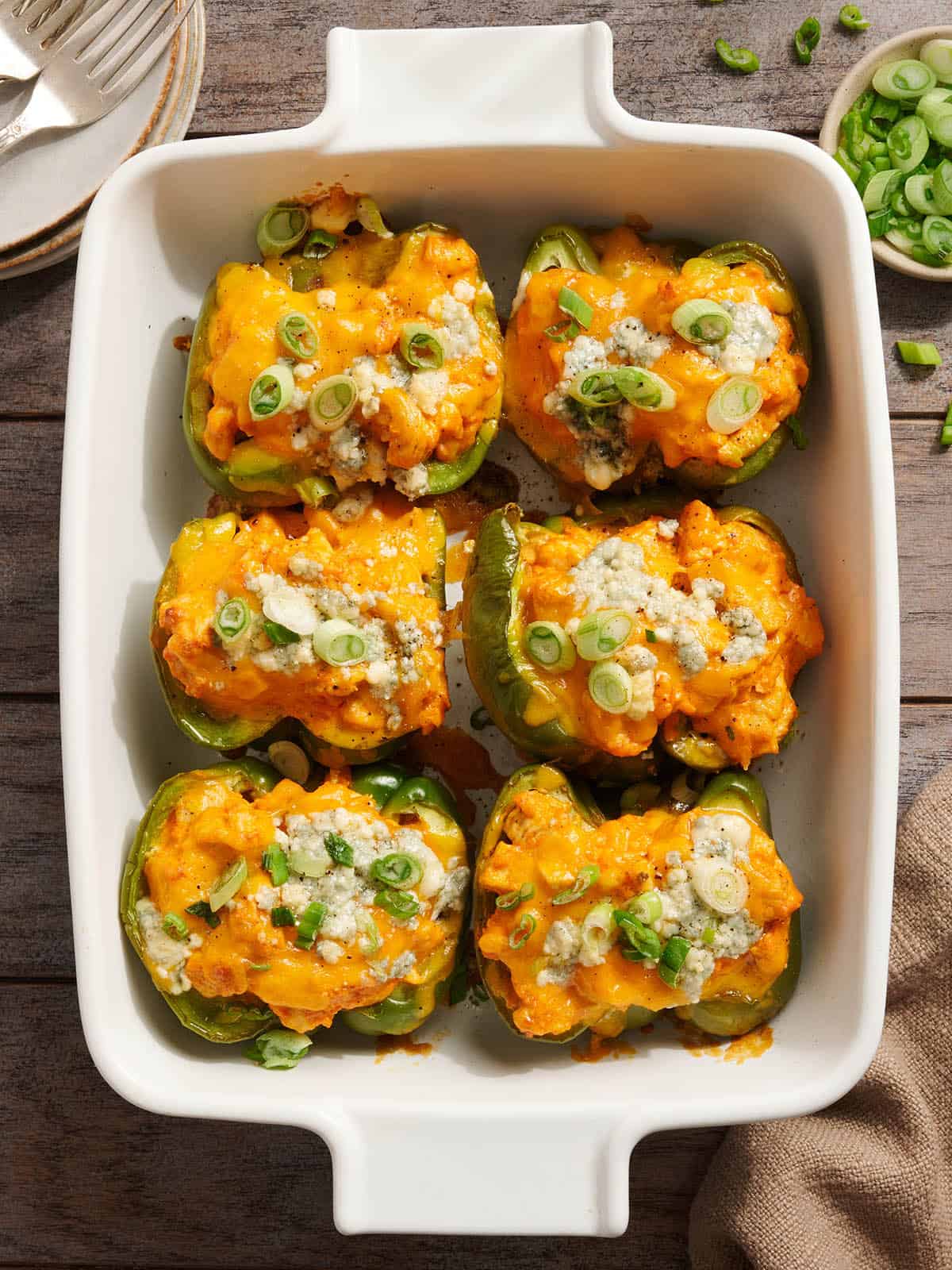 Overhead view of creamy buffalo chicken stuffed peppers in a baking dish.